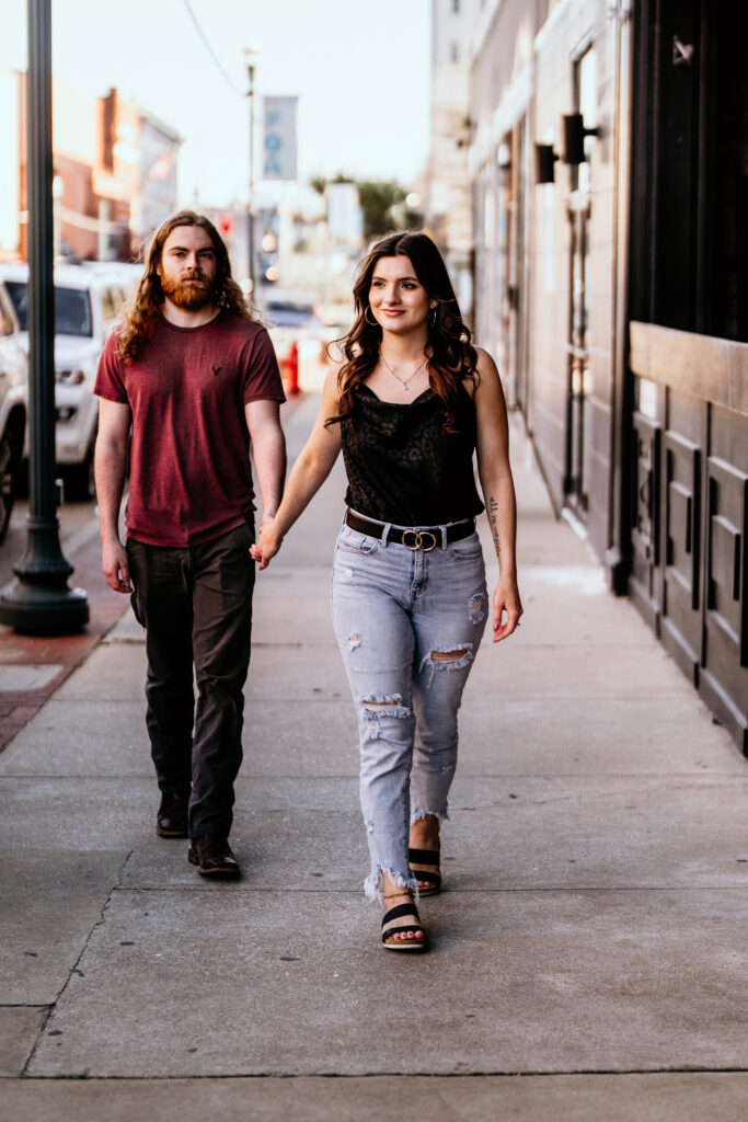 Female leading fiancé on a downtown stroll while looking around