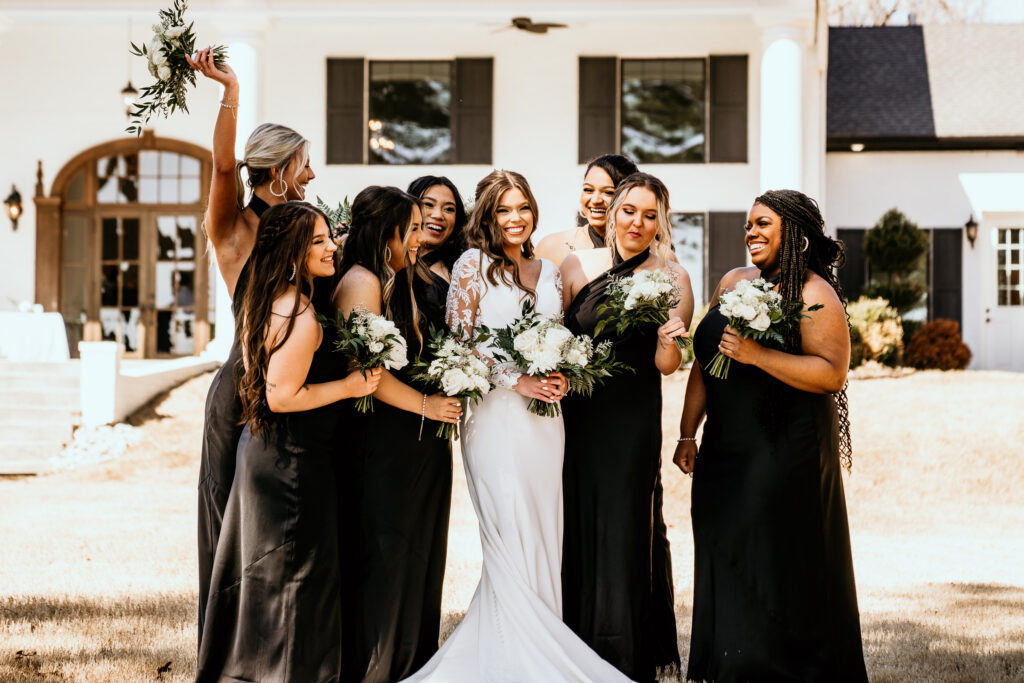 Bride surrounded by the love of her bridal party all smiling and laughing together