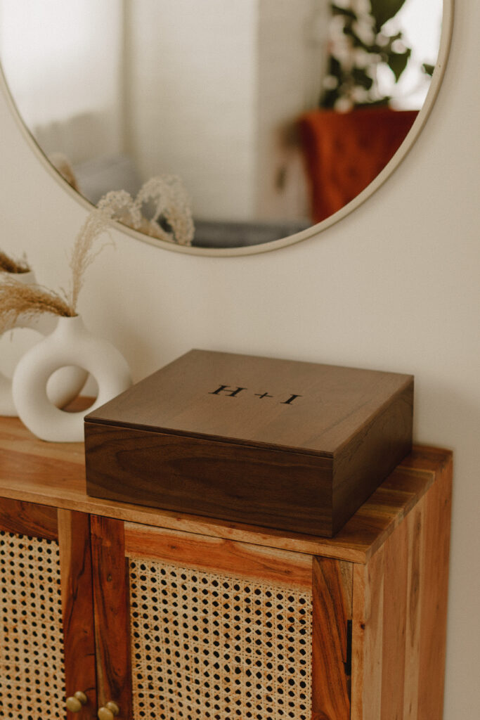 Custom Walnut Box engraved with H + I for the couples initials sitting on a chest in living room