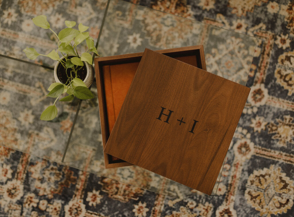 Photo album nested inside its custom walnut storage box, lid cocked to the side giving a peek inside the box