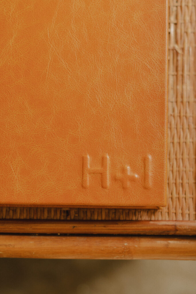 Showcasing of the raised letters on the album that is the couples initials "H + I"