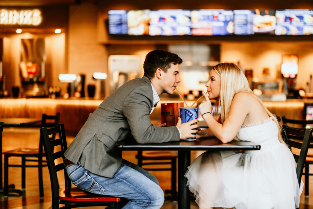 Couple sharing a drink at the movie theatre during their engagement session